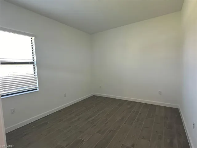 Empty room featuring dark hardwood / wood-style flooring