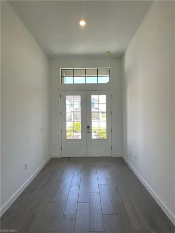 Doorway to outside with dark hardwood / wood-style flooring and french doors