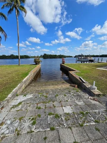 View of sea wall featuring a dock and boat lift