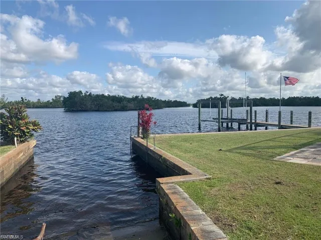 Dock with a lawn, a water view, and boat lift
