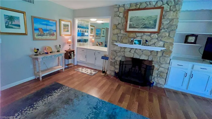 Living room featuring a stone fireplace and hardwood / wood-style flooring