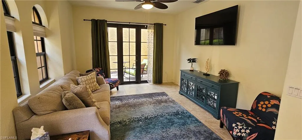 Living room featuring light tile patterned floors and ceiling fan