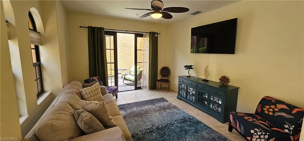 Living room with a ceiling fan, light carpet, and recessed lighting
