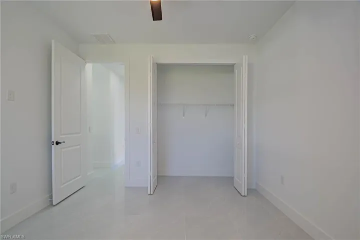 Unfurnished bedroom featuring a closet, baseboards, visible vents, and a ceiling fan