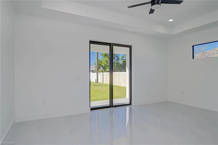 Spare room featuring a ceiling fan, a raised ceiling, recessed lighting, and baseboards