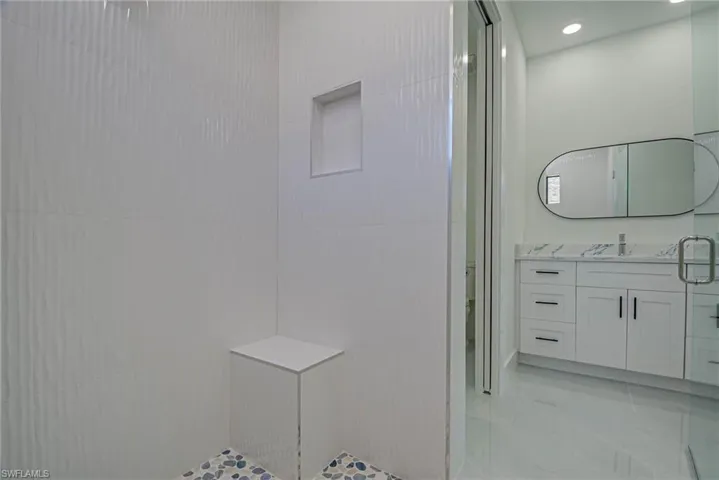 Full bathroom with toilet, vanity, and a tile shower