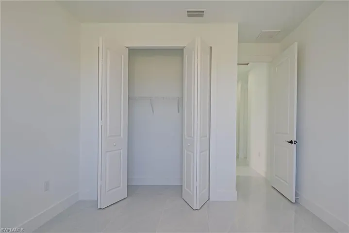 Unfurnished bedroom featuring a closet, visible vents, and baseboards