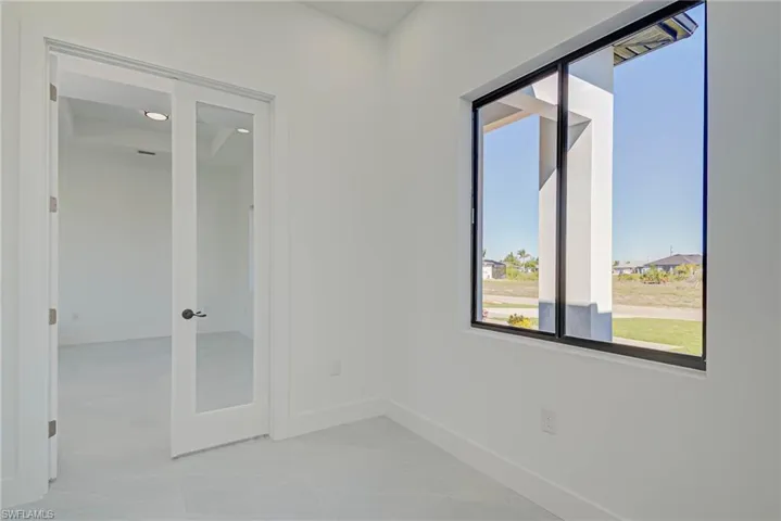 Empty room with french doors and baseboards