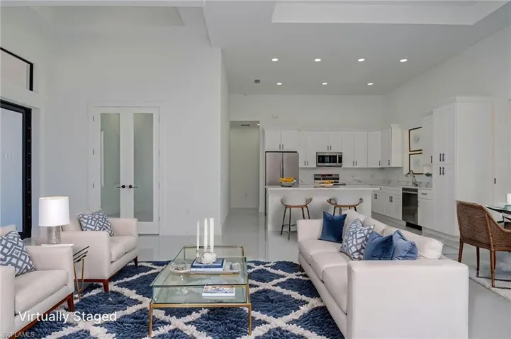 Living room with recessed lighting, french doors, and a towering ceiling