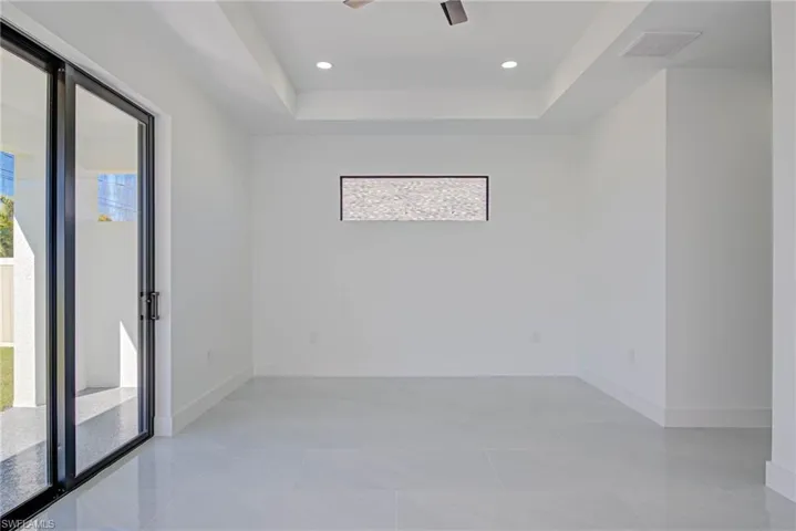 Spare room featuring a tray ceiling, recessed lighting, baseboards, and visible vents