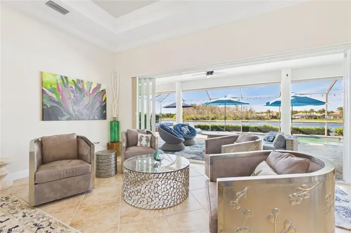 great room looking out large pocket slider to the pool and water view
