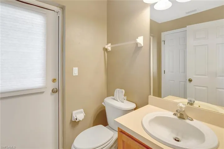 Bathroom featuring visible vents, toilet, vanity, and a wealth of natural light