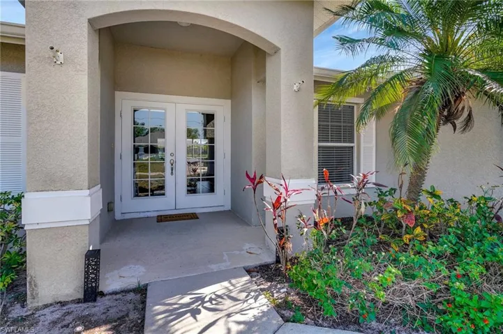 View of exterior entry featuring french doors and stucco siding
