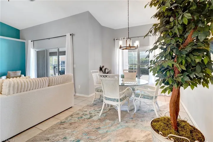 Dining space featuring tile patterned flooring, baseboards, and a notable chandelier