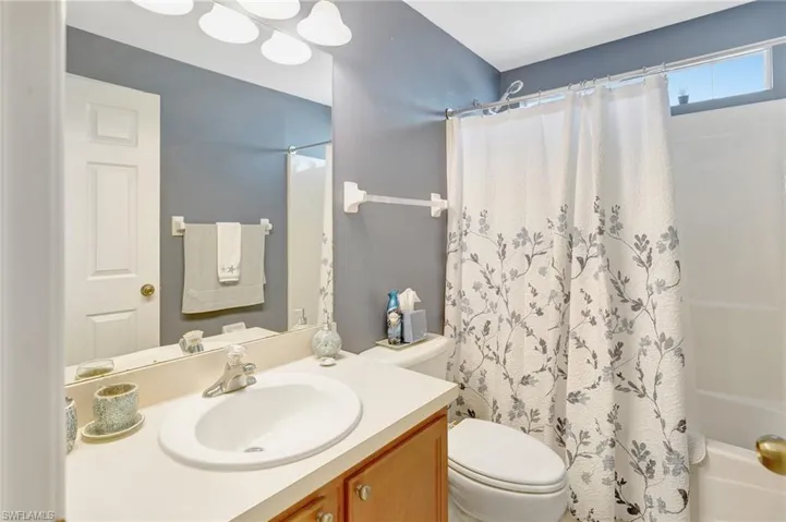 Full bath featuring toilet, shower / bath combo, and vanity