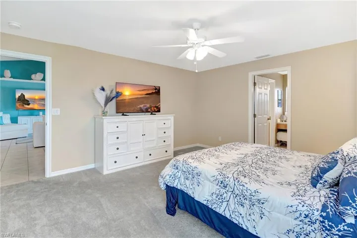 Carpeted bedroom featuring visible vents, baseboards, and a ceiling fan