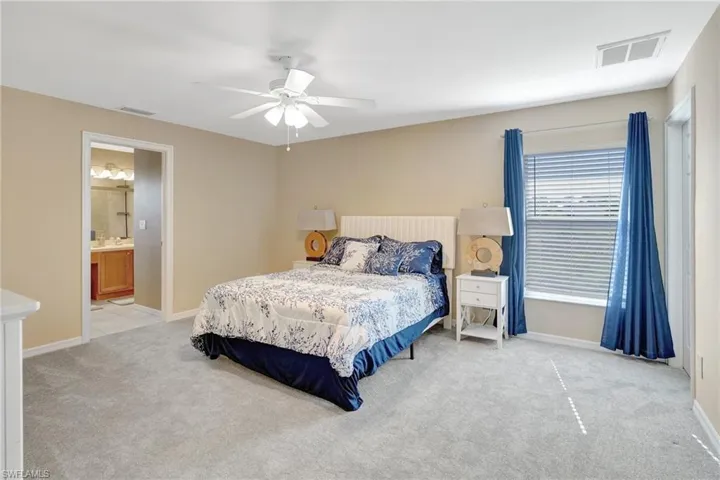 Bedroom with visible vents, baseboards, a ceiling fan, and carpet floors