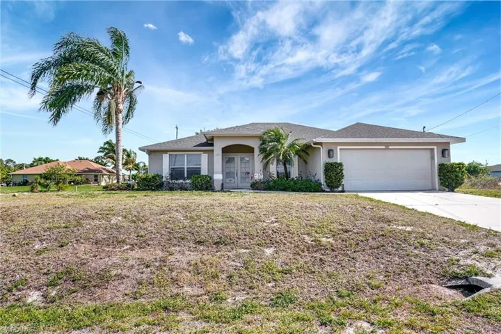 Ranch-style house with french doors, driveway, stucco siding, and a garage