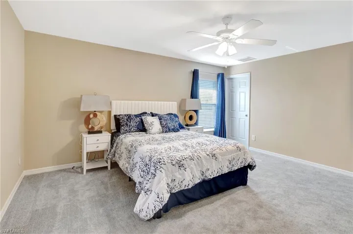 Bedroom featuring baseboards, a ceiling fan, visible vents, and carpet floors