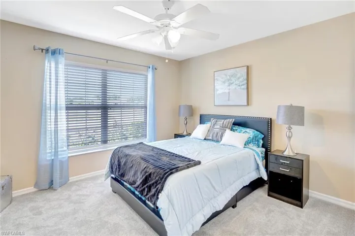 Bedroom with carpet flooring, baseboards, and a ceiling fan
