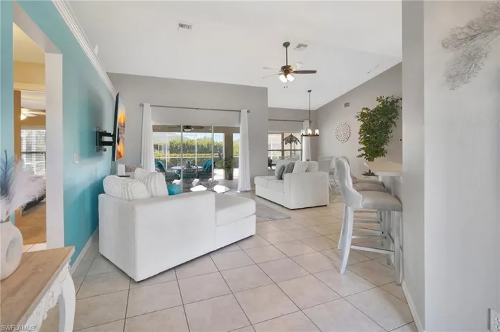 Living area featuring visible vents, ceiling fan, baseboards, and light tile patterned floors