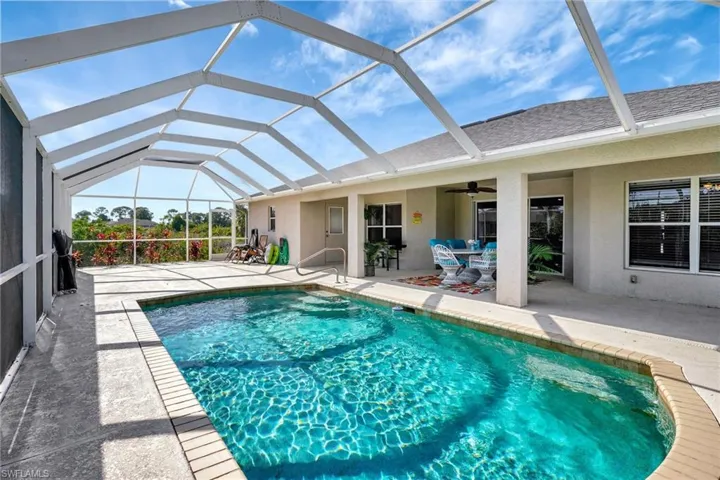 Outdoor pool featuring a patio area, glass enclosure, and ceiling fan