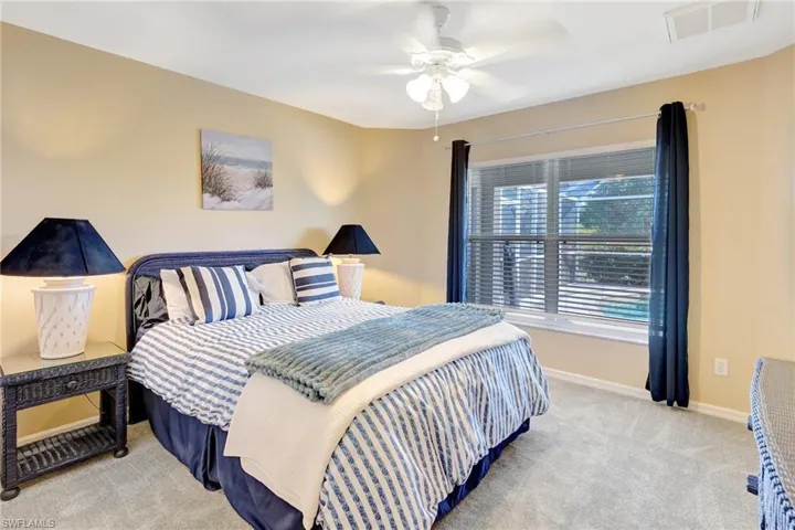 Carpeted bedroom featuring visible vents, baseboards, and a ceiling fan