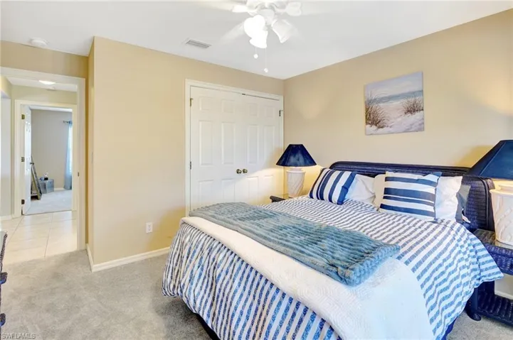 Carpeted bedroom with a closet, ceiling fan, baseboards, and visible vents