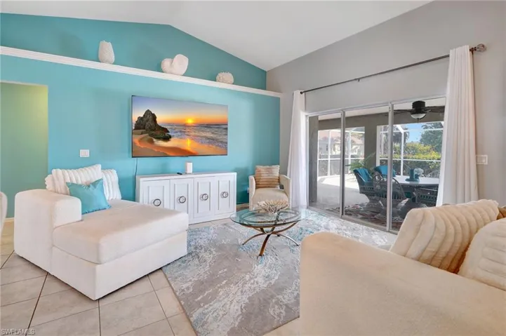Living room with tile patterned flooring and vaulted ceiling