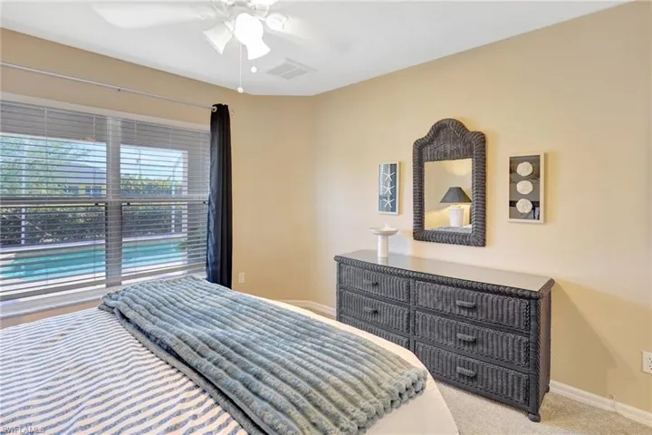 Bedroom featuring carpet flooring, visible vents, baseboards, and ceiling fan