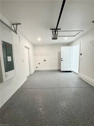 Garage featuring electric panel and a garage door opener