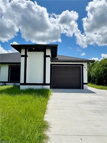 View of front of home featuring driveway, a garage, roof with shingles, and stucco siding