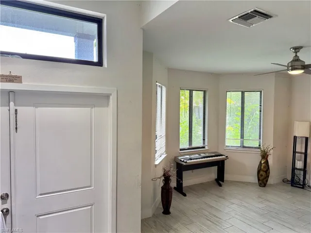 Foyer featuring healthy amount of natural light, light wood finished floors, and ceiling fan