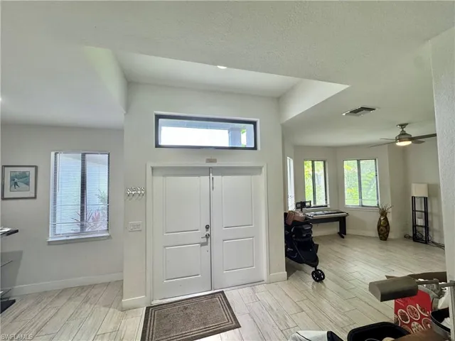 Foyer entrance featuring wood finish floors, ceiling fan, and a textured ceiling