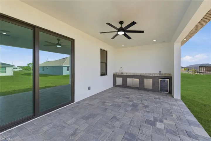 View of patio / terrace with a ceiling fan, beverage cooler, and exterior kitchen