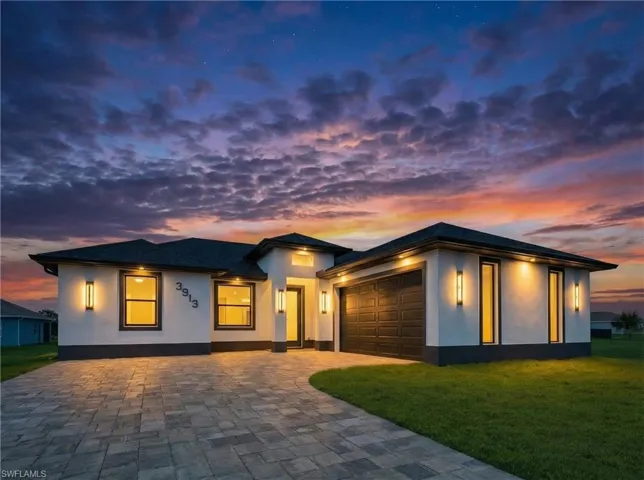 Prairie-style house with stucco siding, a lawn, decorative driveway, and an attached garage