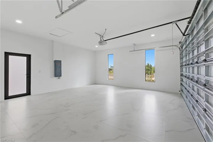 Garage with electric panel and recessed lighting