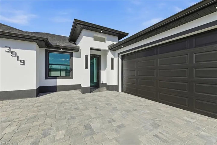 Property entrance featuring decorative driveway and stucco siding