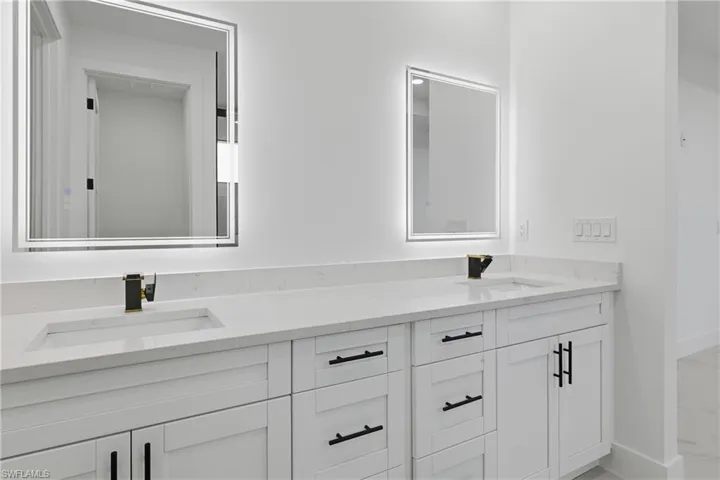 Bathroom featuring double vanity and baseboards