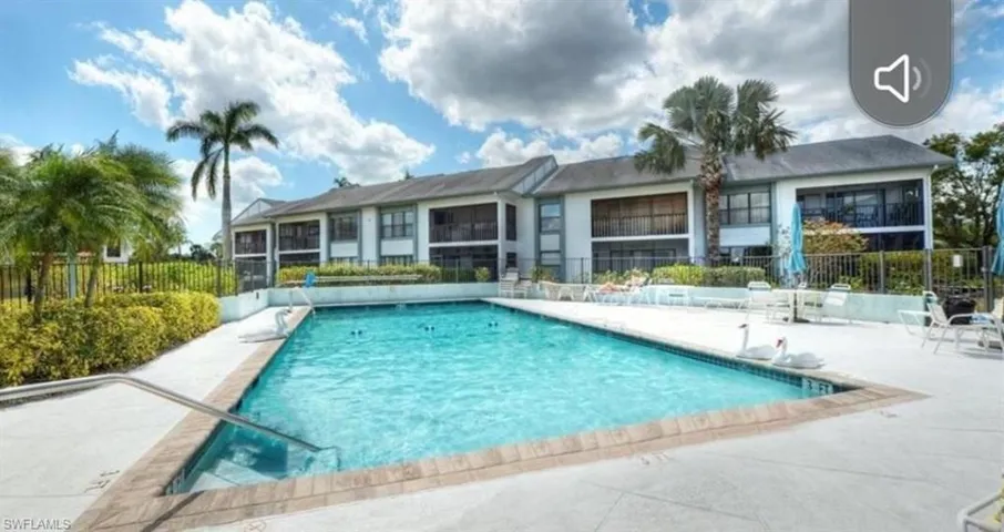 Community pool with a patio area and fence