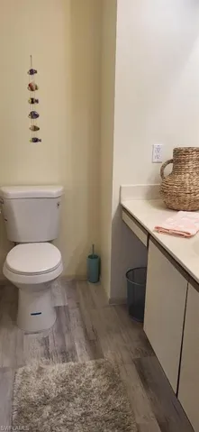 Bathroom with toilet and wood finished floors