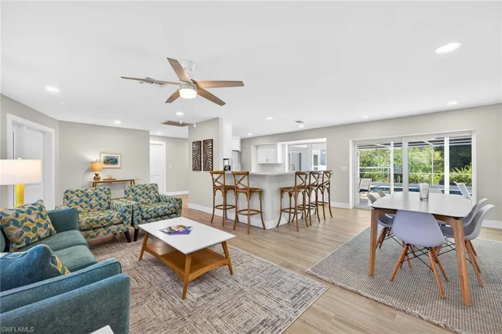 Living room with light wood-type flooring, ceiling fan, and recessed lighting