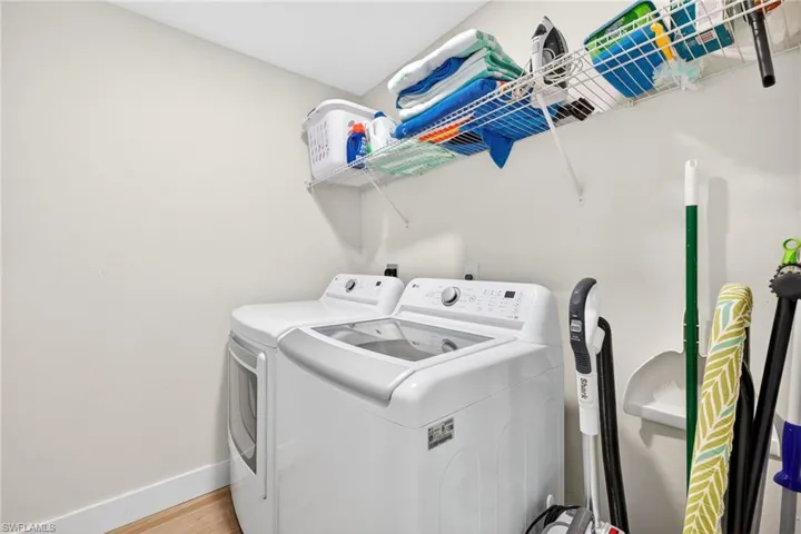 Laundry room with washer and dryer and light wood-style flooring