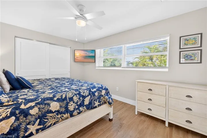 Bedroom with light wood-style floors, a ceiling fan, and a closet