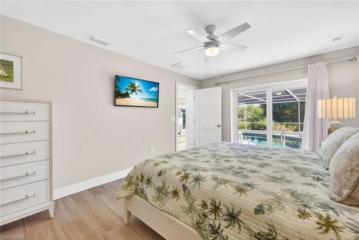 Primary Bedroom with light wood-style flooring, access to exterior, and ceiling fan