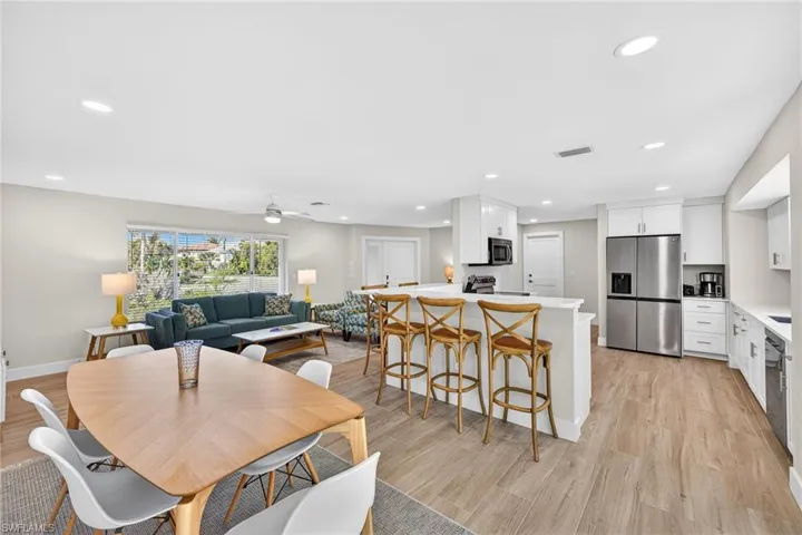 Dining room with light wood-type flooring, ceiling fan, and recessed lighting
