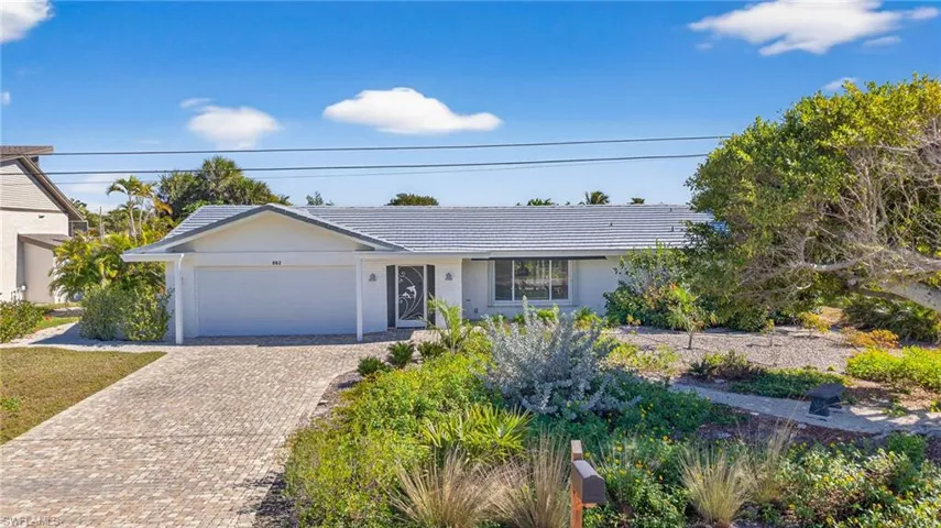 Ranch-style home with decorative driveway, an attached garage, and stucco siding