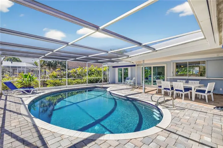 Outdoor pool with a patio area, a sunroom, a lanai, and outdoor dining area