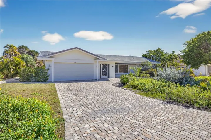 Single story home with decorative driveway and an attached garage