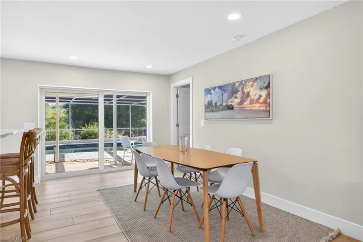 Dining room with light wood-style flooring and recessed lighting